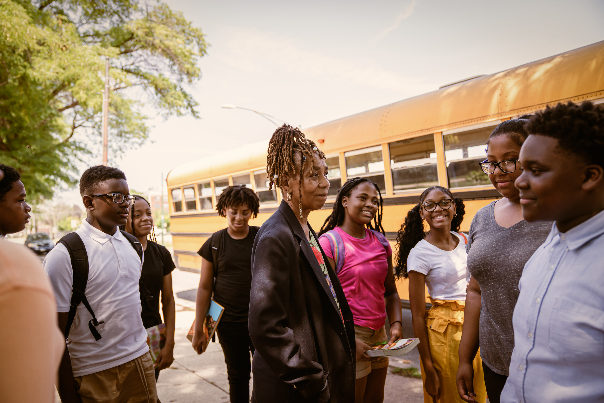 Junior high Black students arrive to school via school bus.